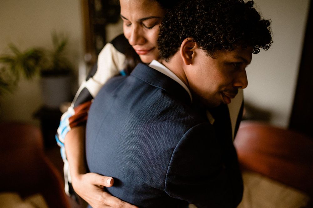 Couple sharing a warm embrace in romantic indoor lighting.