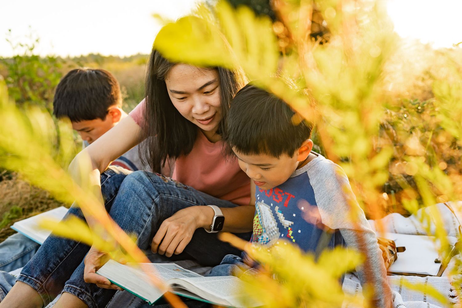 Bellevue family photographer captures mother reading the bible to her children at sunset at Marymoor Park