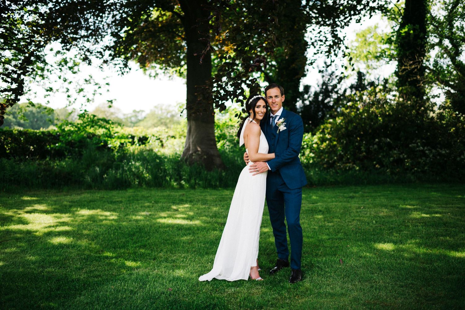 Summer wedding photography session in a lush green garden setting.