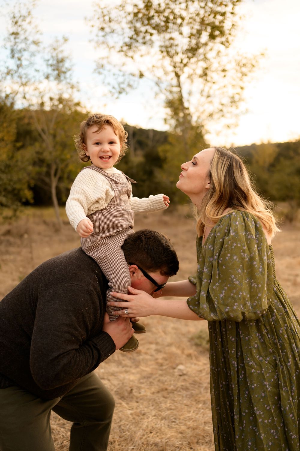 Thousand Oaks golden grassy field family photos by Ventura family photographer of family playing with their toddler son during photoshoot