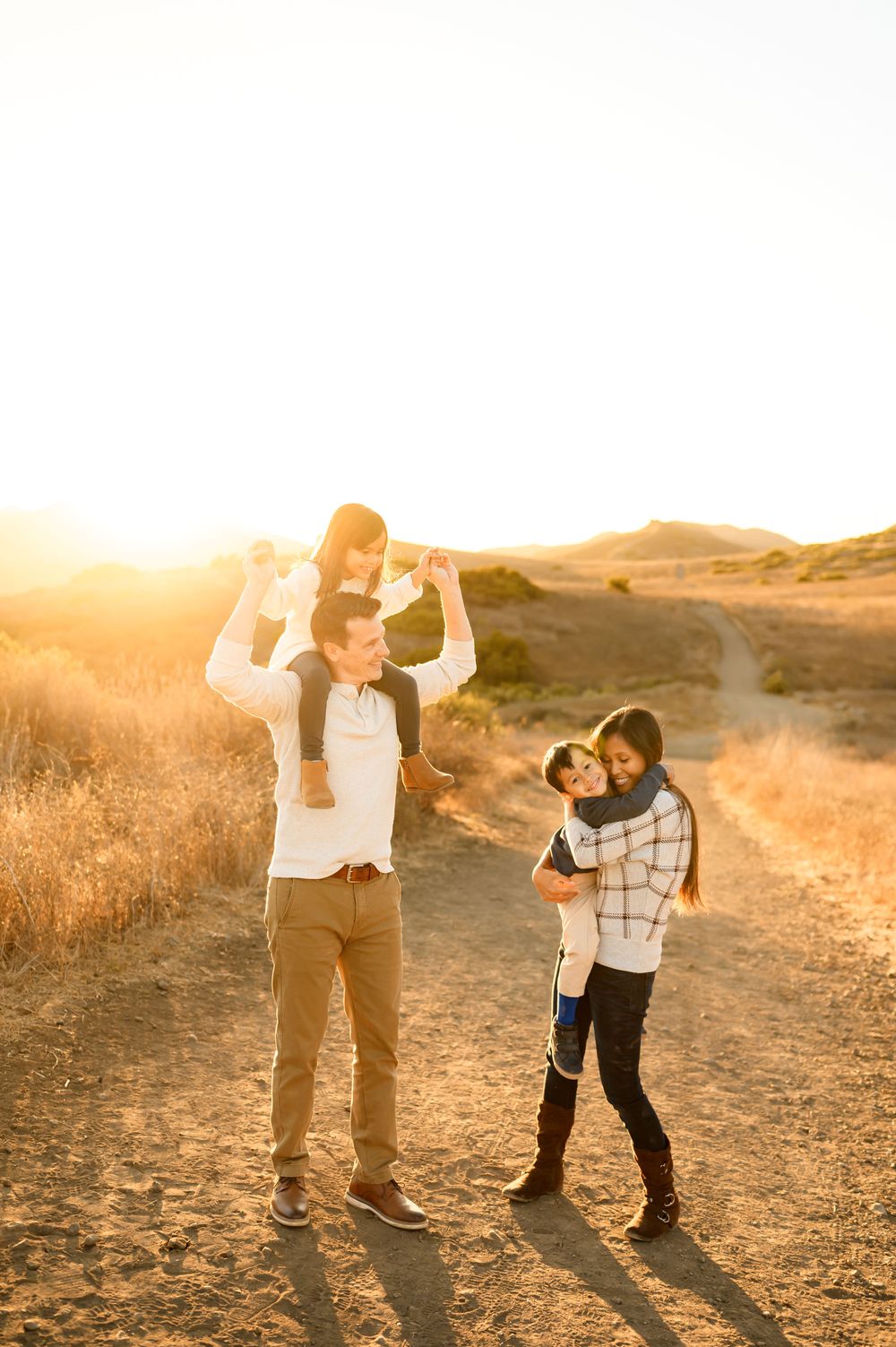 Newbury Park golden field family photos by Ventura family photographer of family cuddling up with their two young children during photoshoot