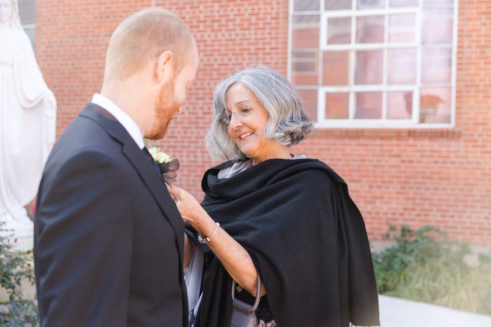 Sweet moment shared outside brick building during wedding day.