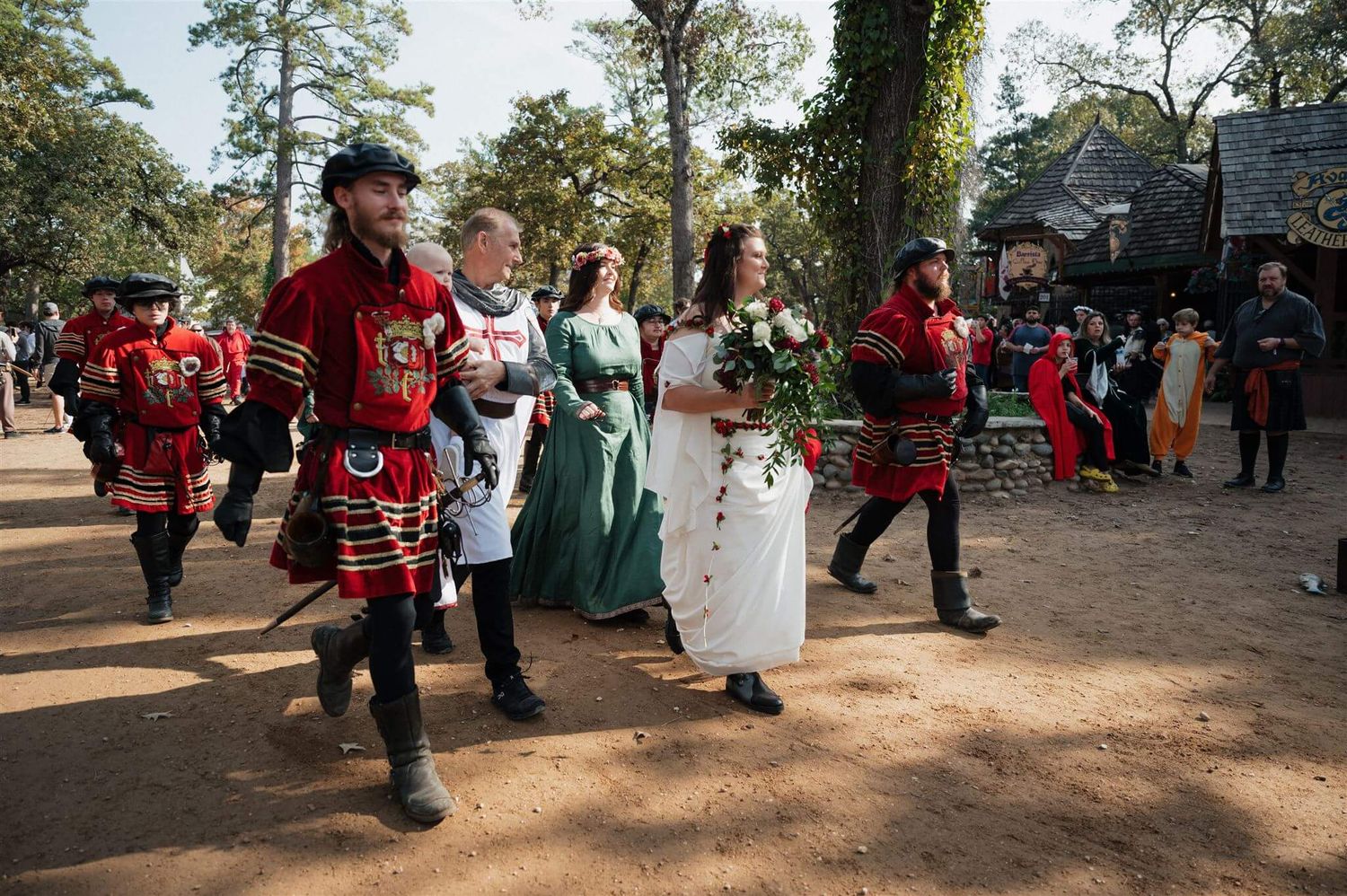 Medieval costumed performers escort a wedding party through a Renaissance festival grounds.