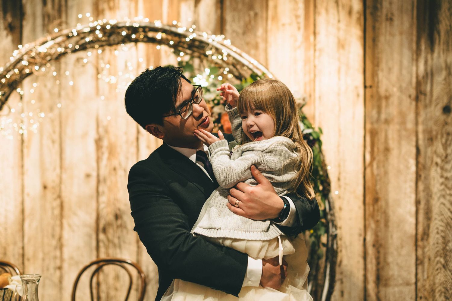 groom and flower girl having a sweet moment.