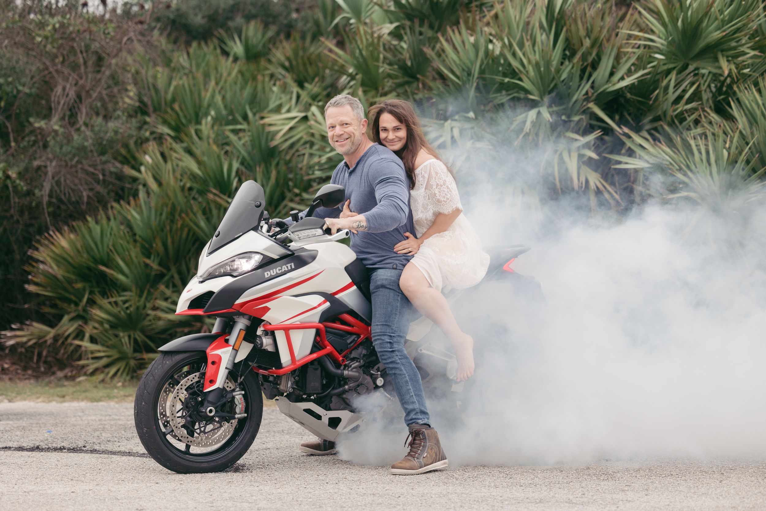 Motorcycle engagement photoshoot with smoke effects and a white sport bike.