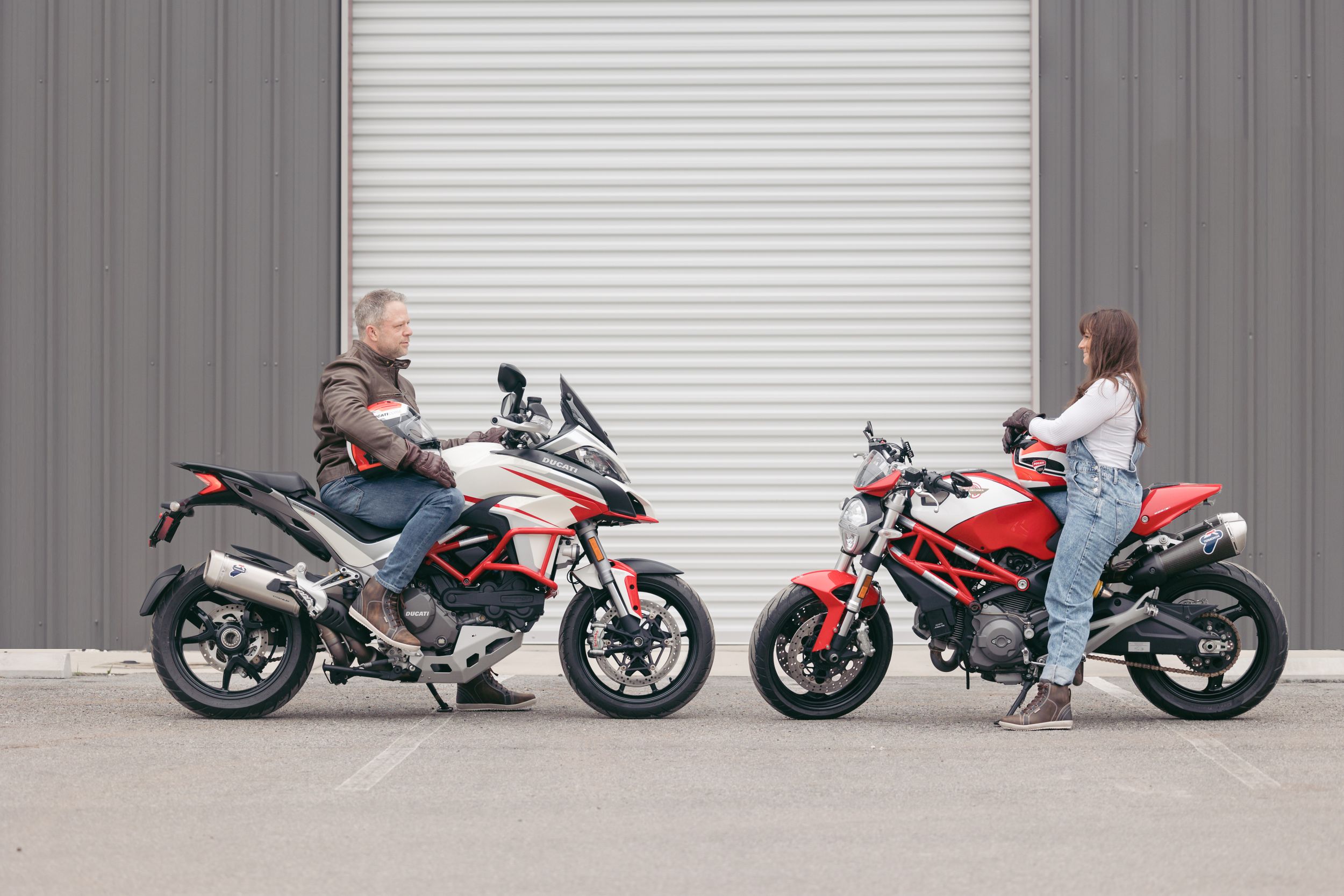 Collection of motorcycles arranged in front of industrial building for engagement photoshoot.
