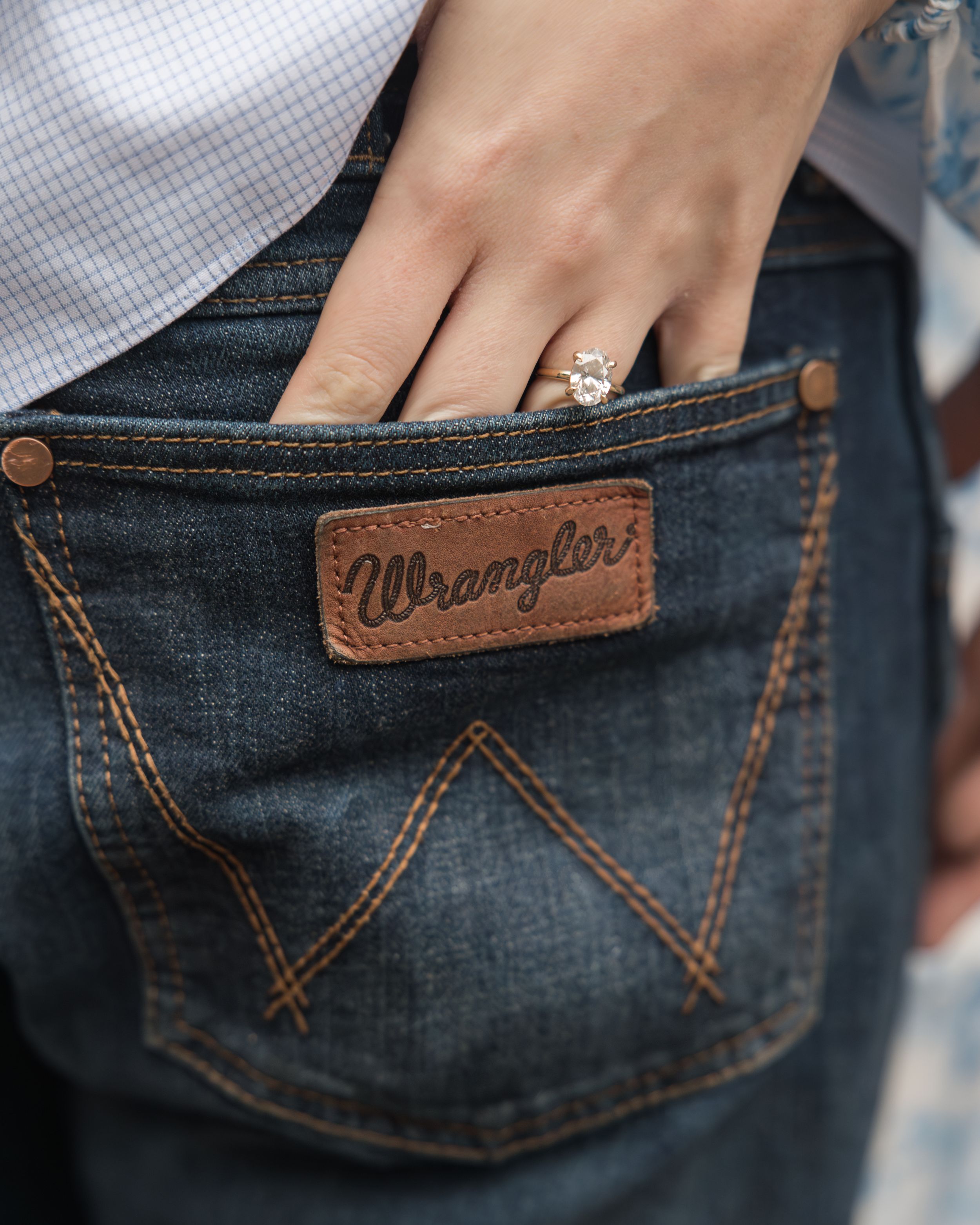 Close-up of a diamond ring and Wrangler jeans pocket detail.