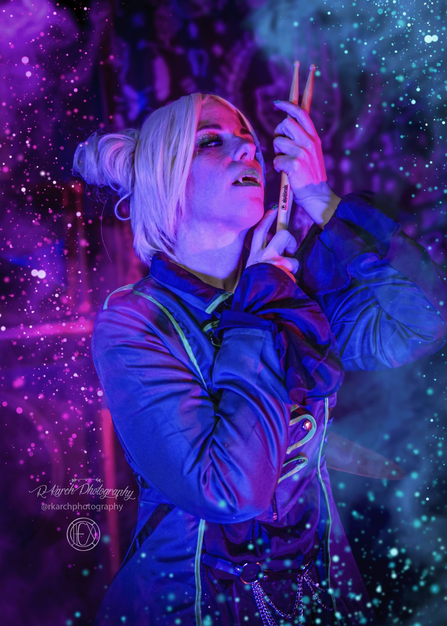 Singer performs passionately against cosmic purple and blue lighting effects.