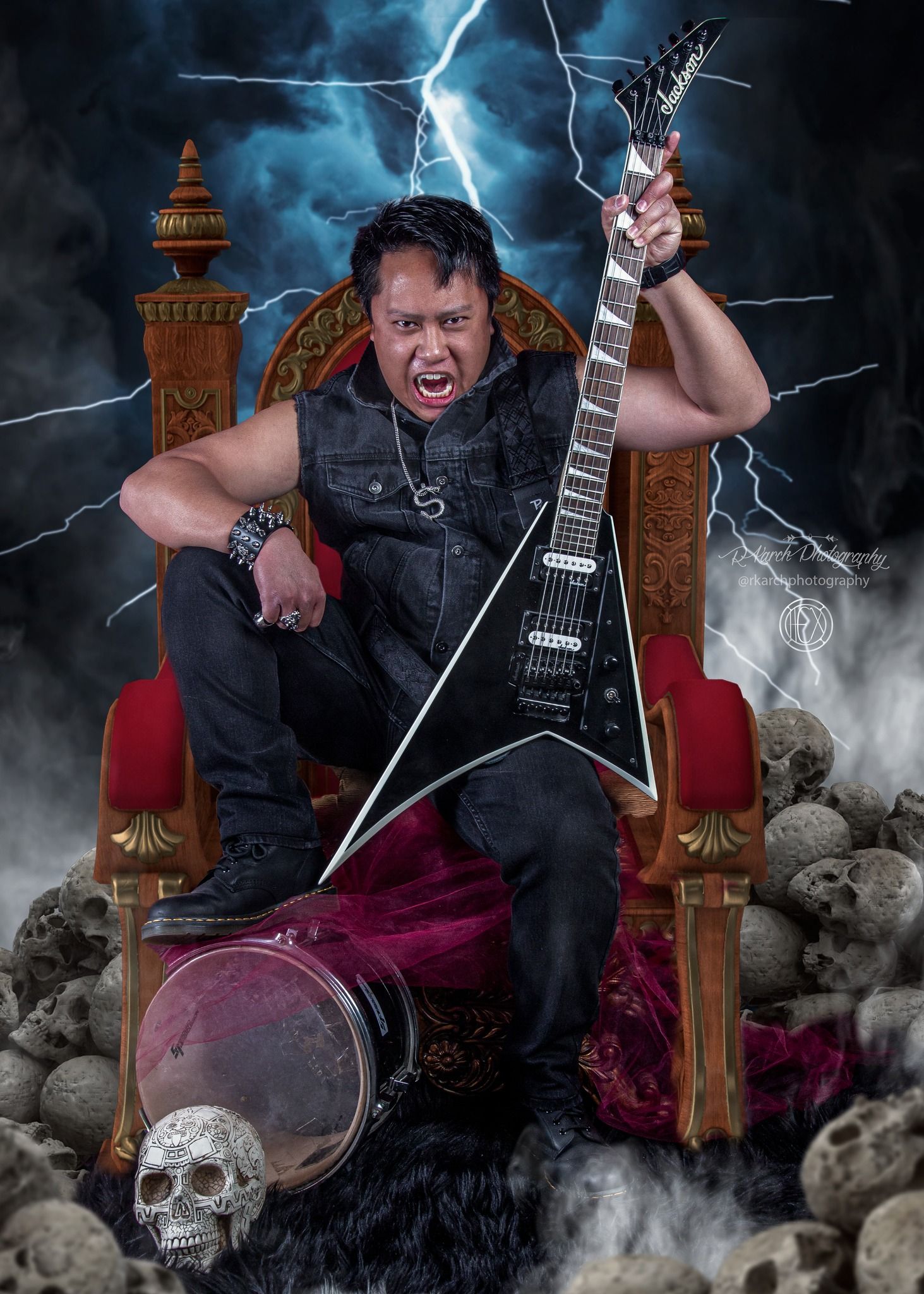 Metal guitarist poses dramatically on throne with lightning effects and fog.