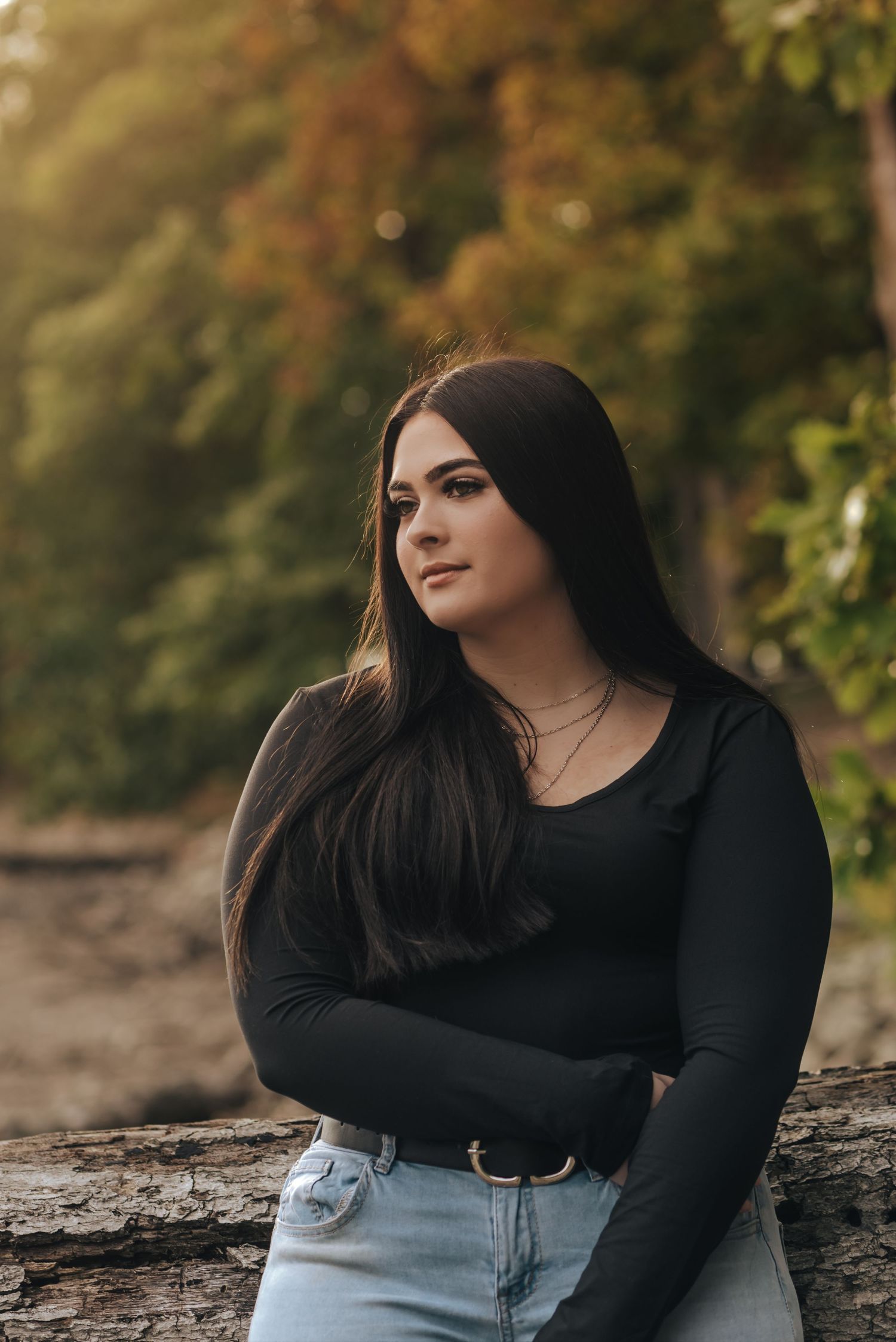 senior girl looks off in the distance on the beach