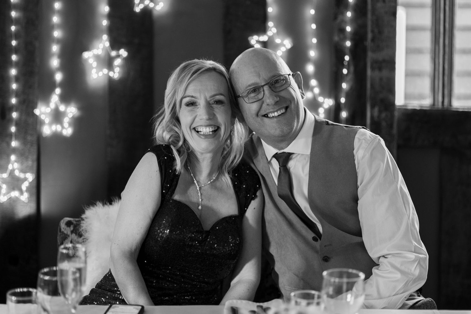 Bride and groom sitting at their top table and smiling.