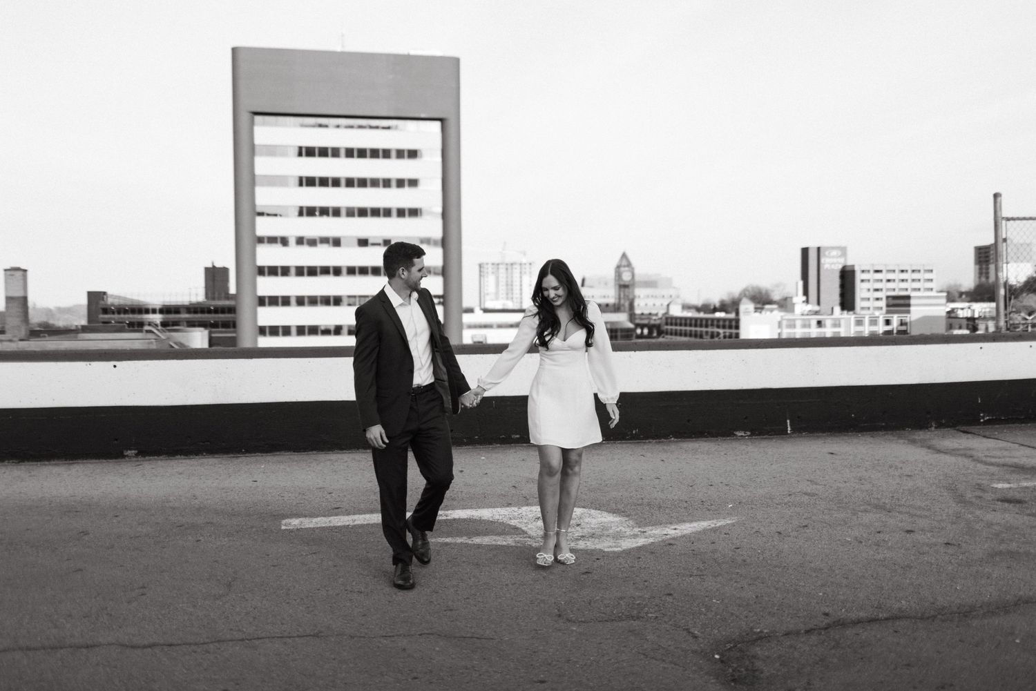 Couple walking on urban rooftop in black and white photography.
