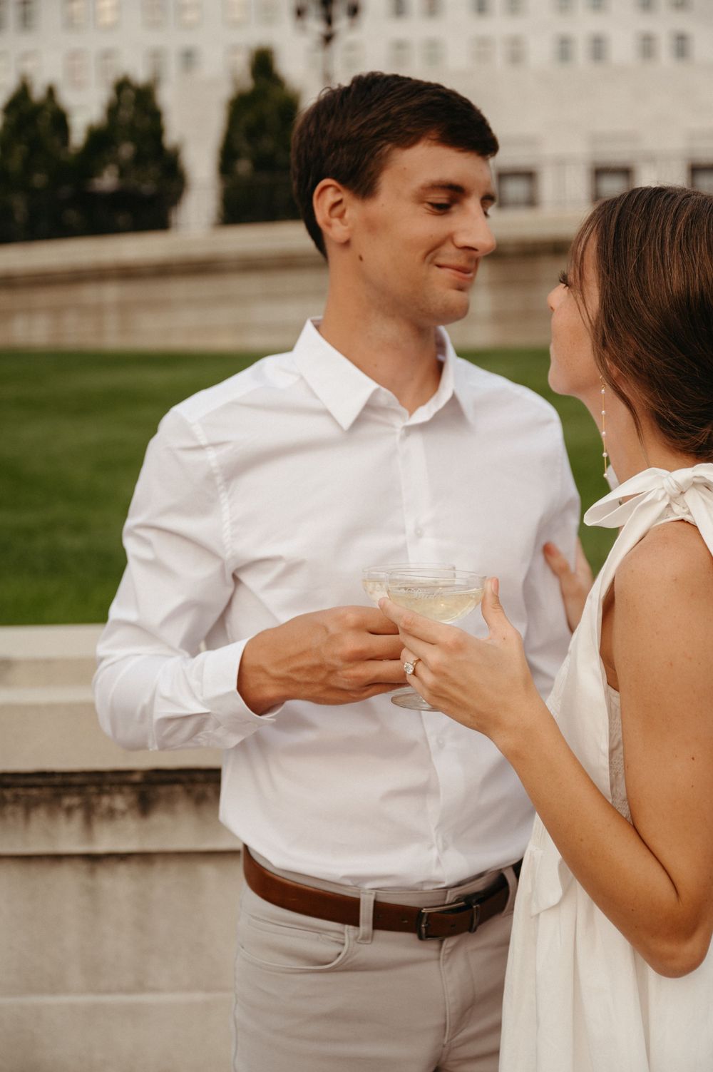 A couple shares champagne and loving glances on an elegant stone terrace.