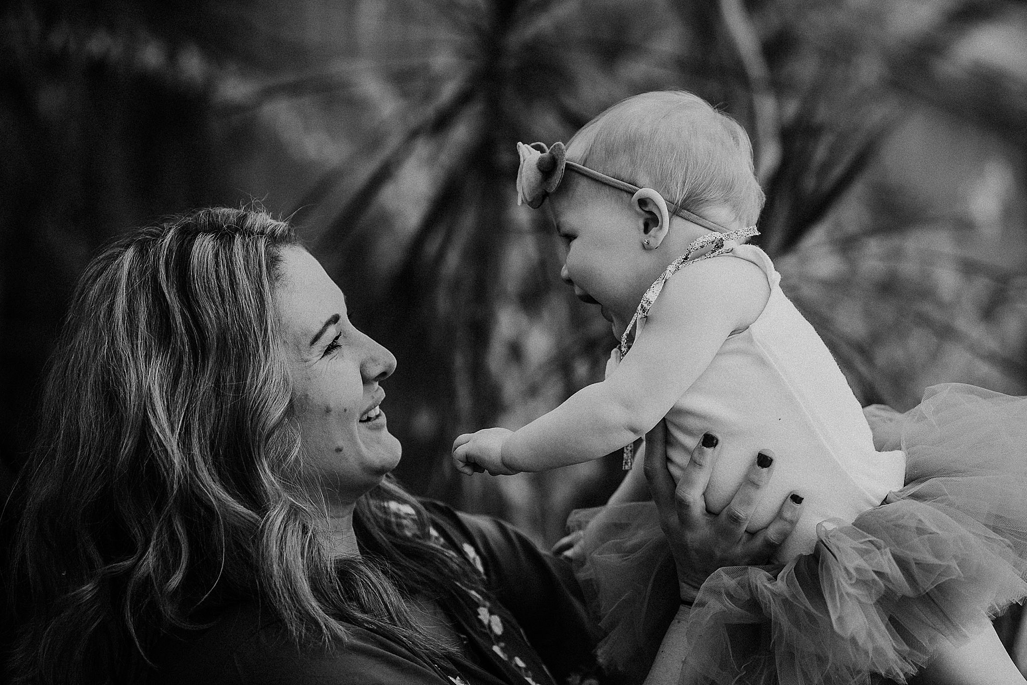 Black and white image capturing a joyful moment between parent and baby.
