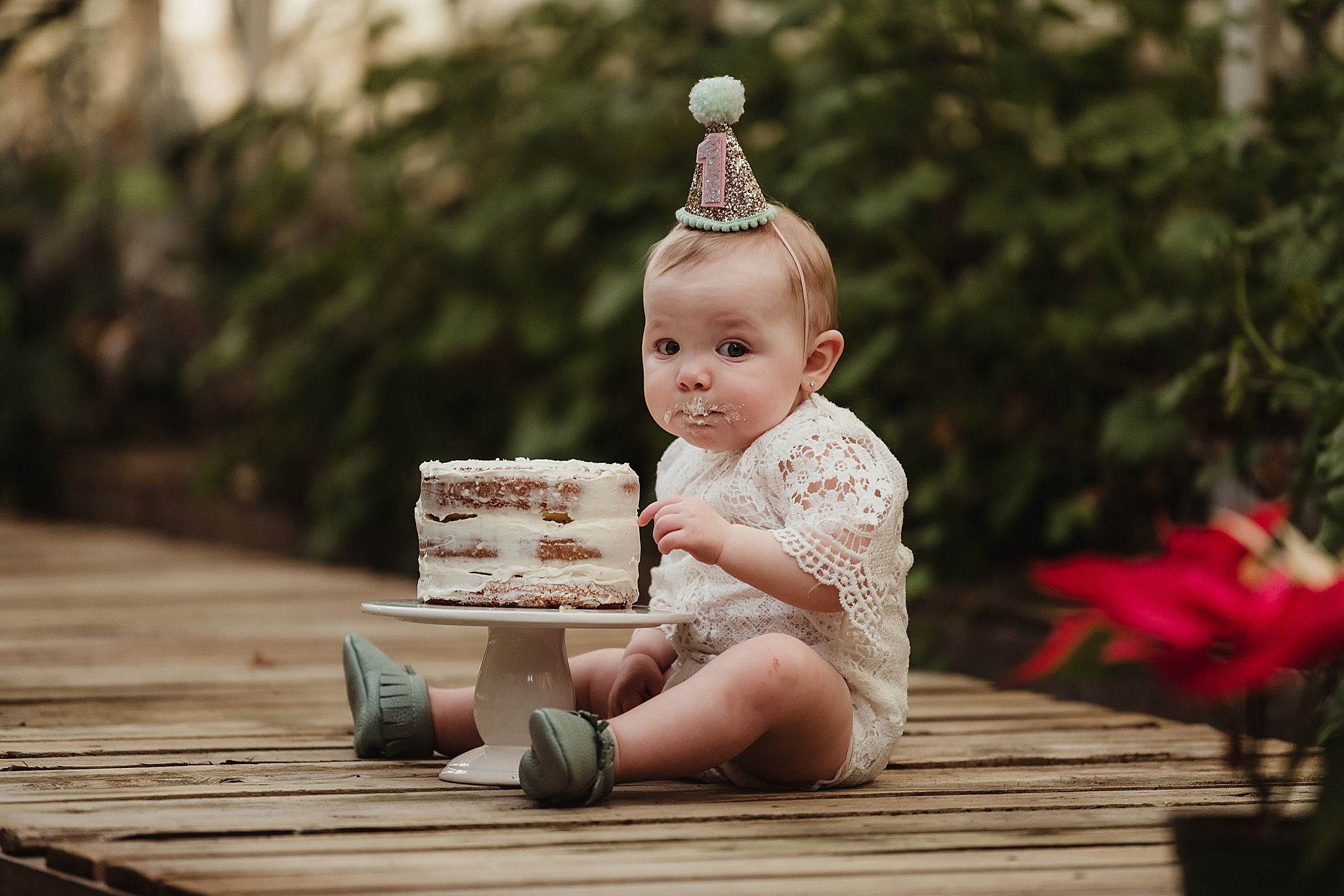 A celebration setup on a wooden platform with a small cake and festive decorations.