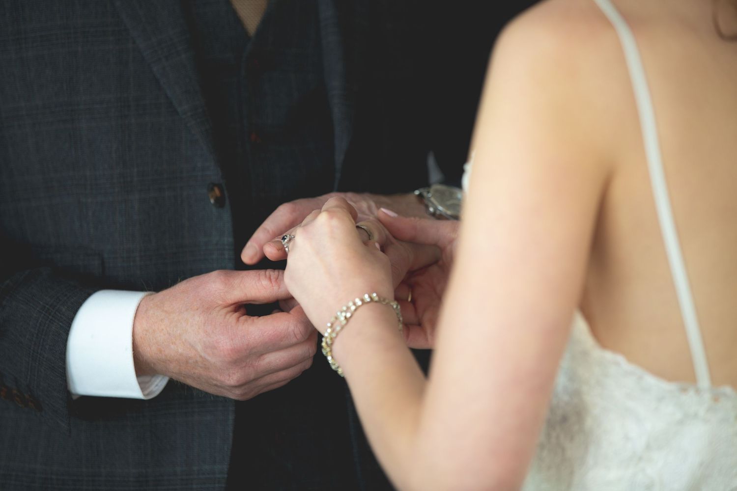 Detailed shot of wedding ring being placed on finger during ceremony.