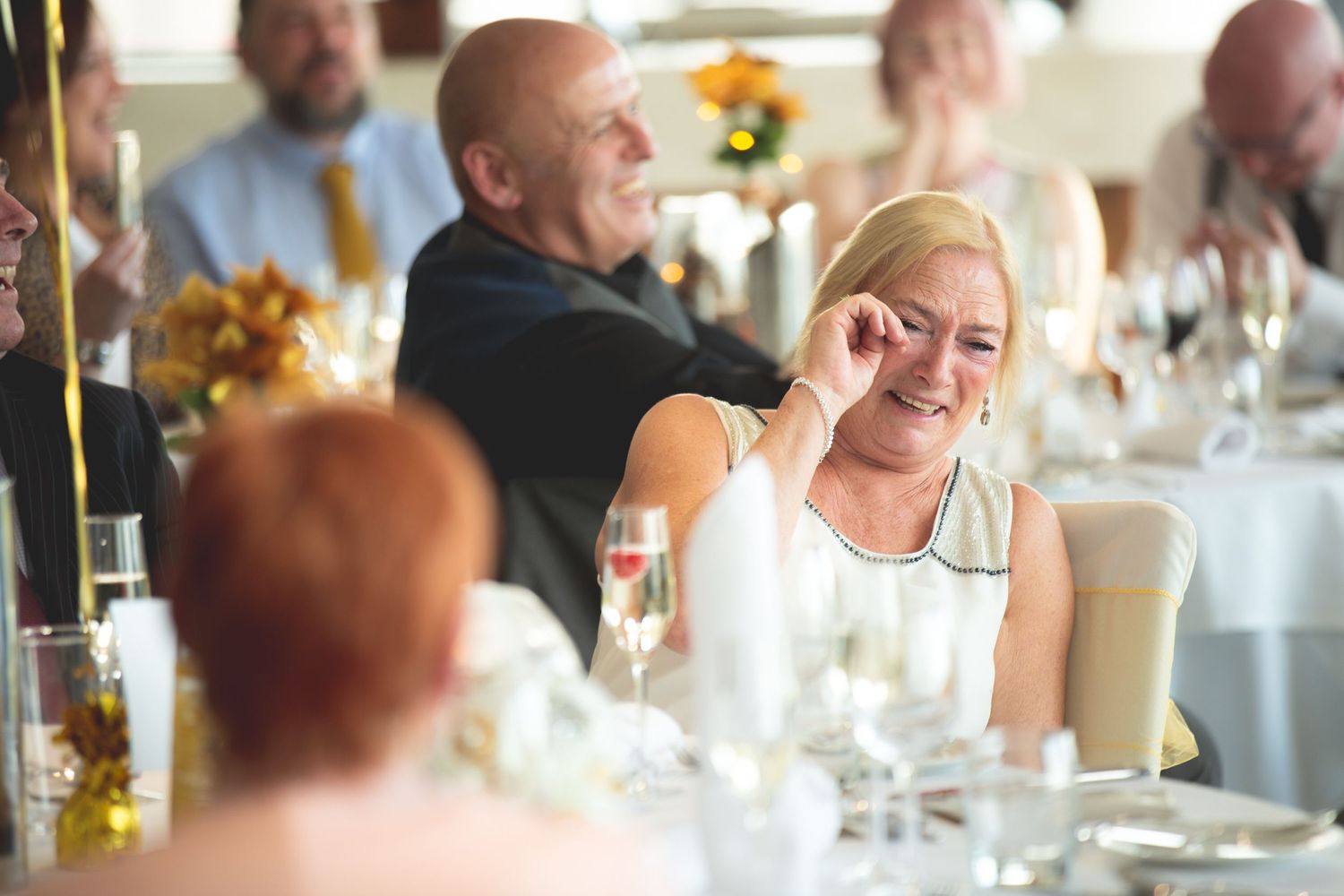 Guests mingling and socializing during an elegant indoor dining event with floral decor.