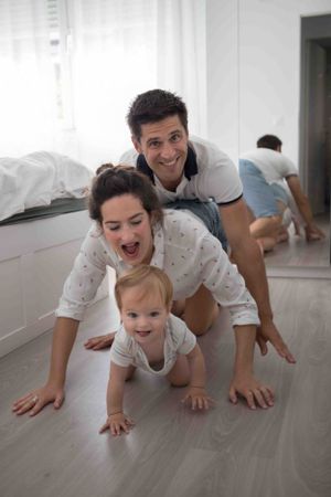 padres jugando con su bebe en casa