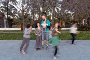Group playing energetically outdoors with motion blur capturing their movements.