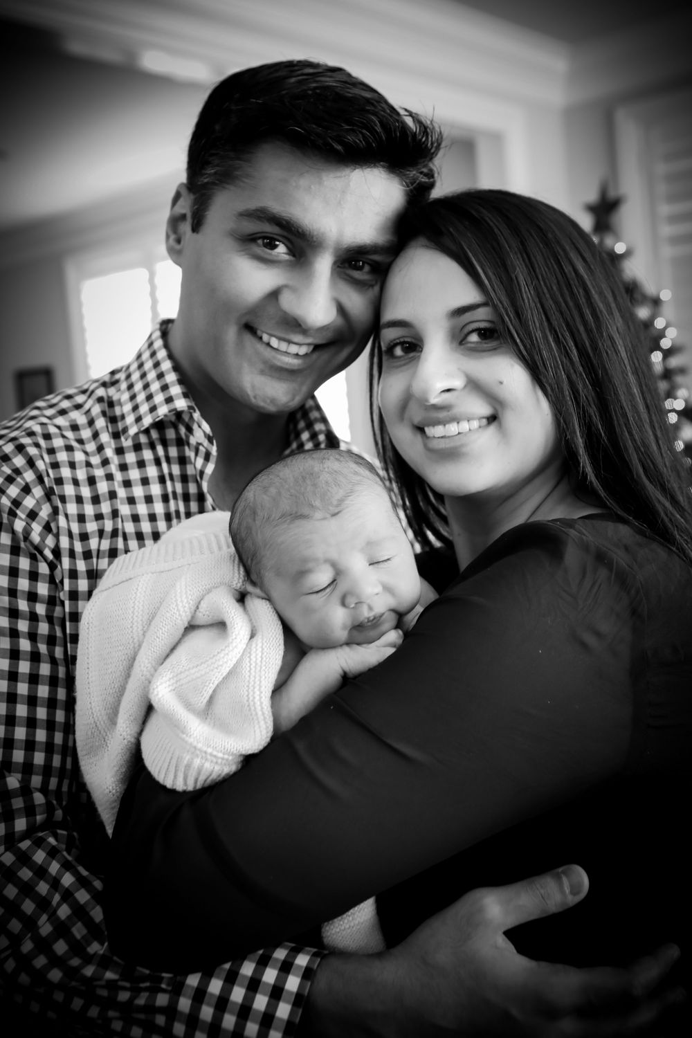 Intimate black and white portrait of family with newborn.