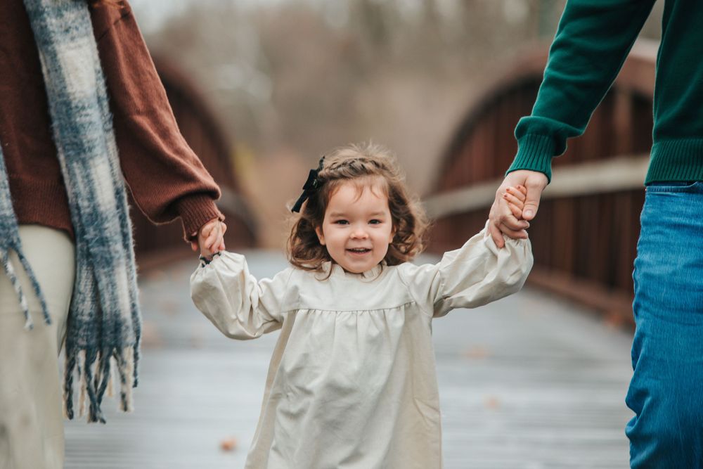 Close-up shots of hands holding while walking on a wooden bridge.