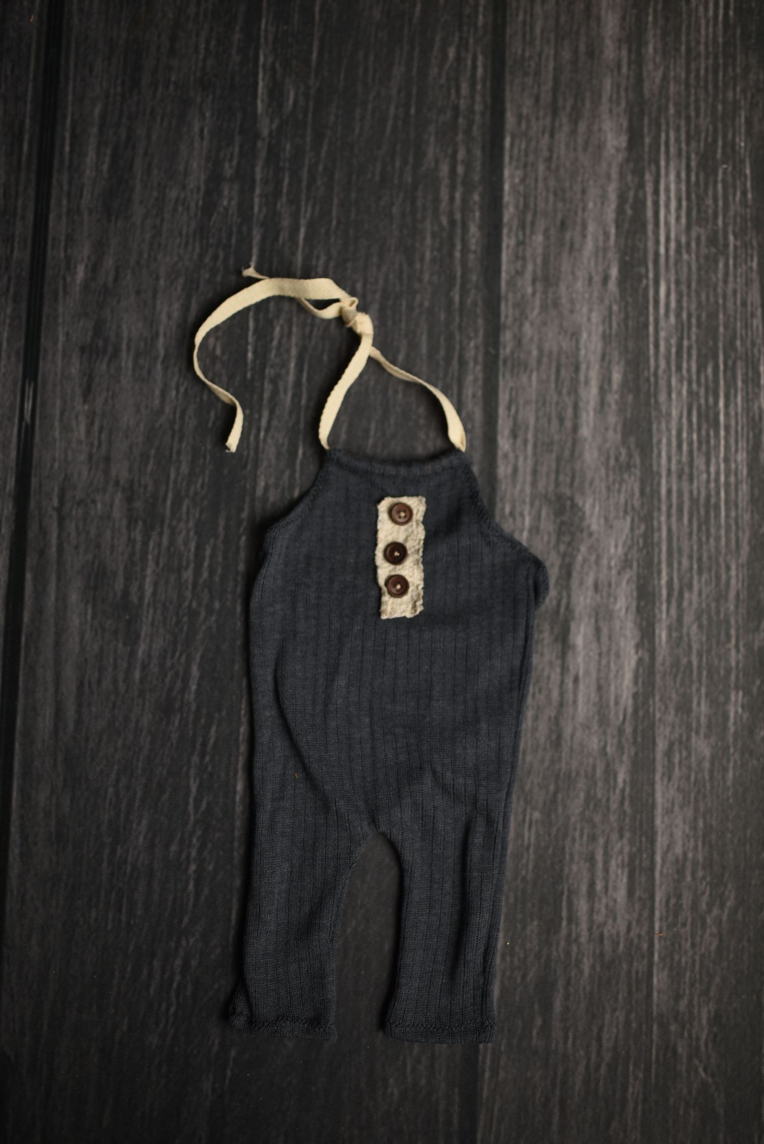 Black sleeveless tank top laid flat on dark wooden surface.