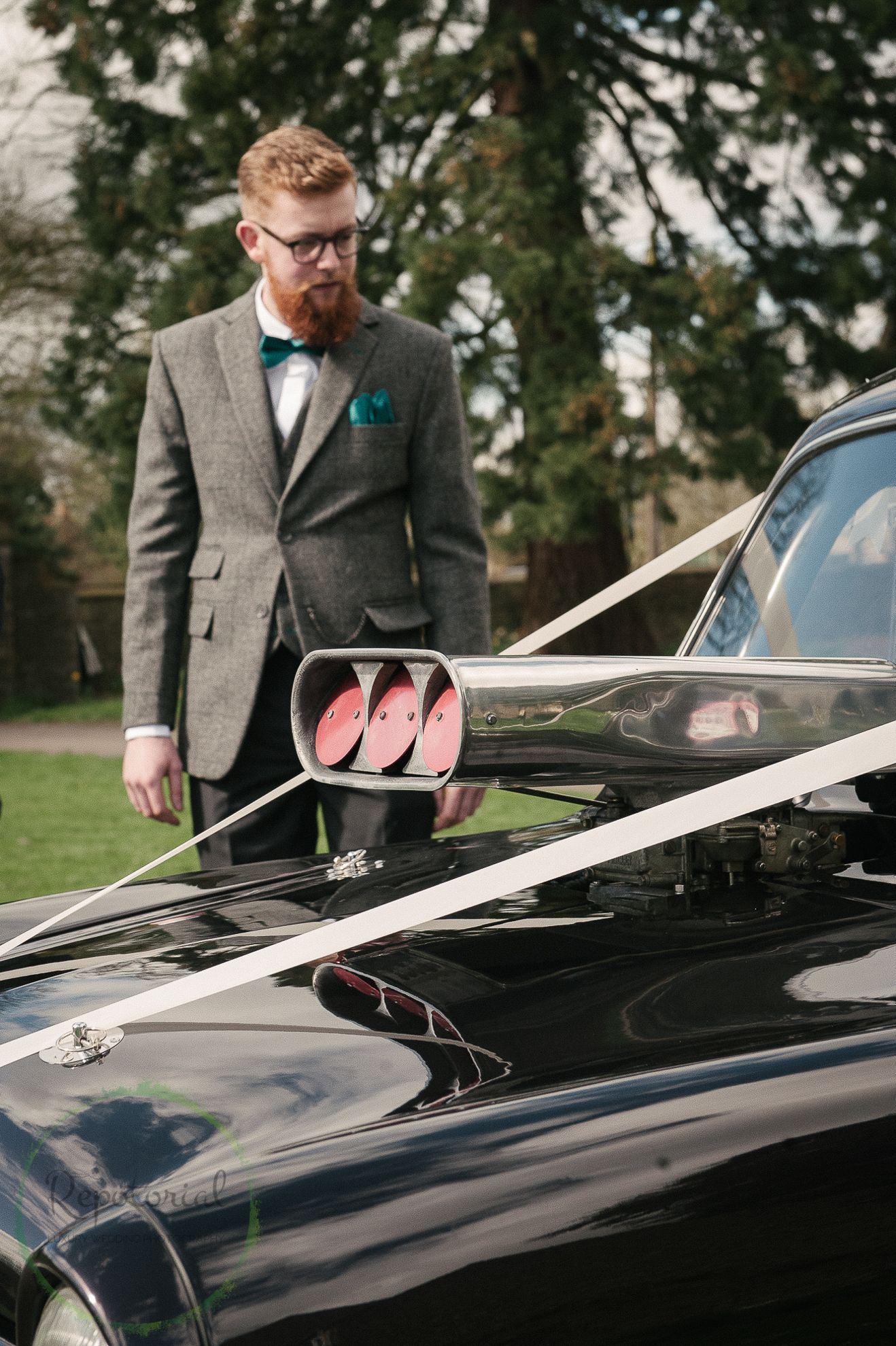 groom admiring his car, a wedding hotrod with ribbons
