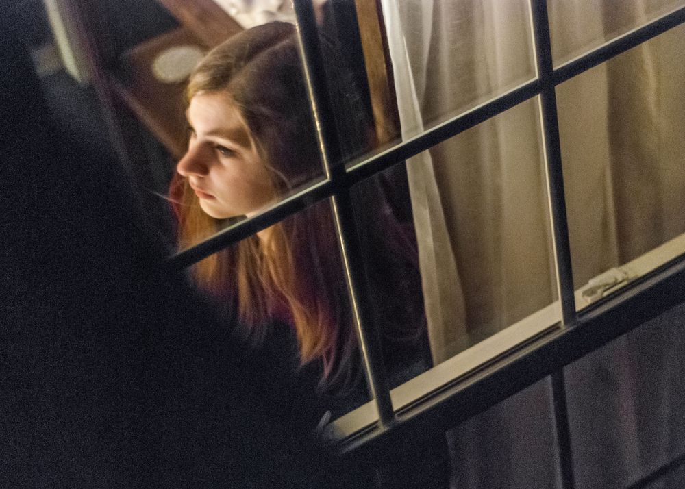 Woman through a window at night in Greenville, South Carolina