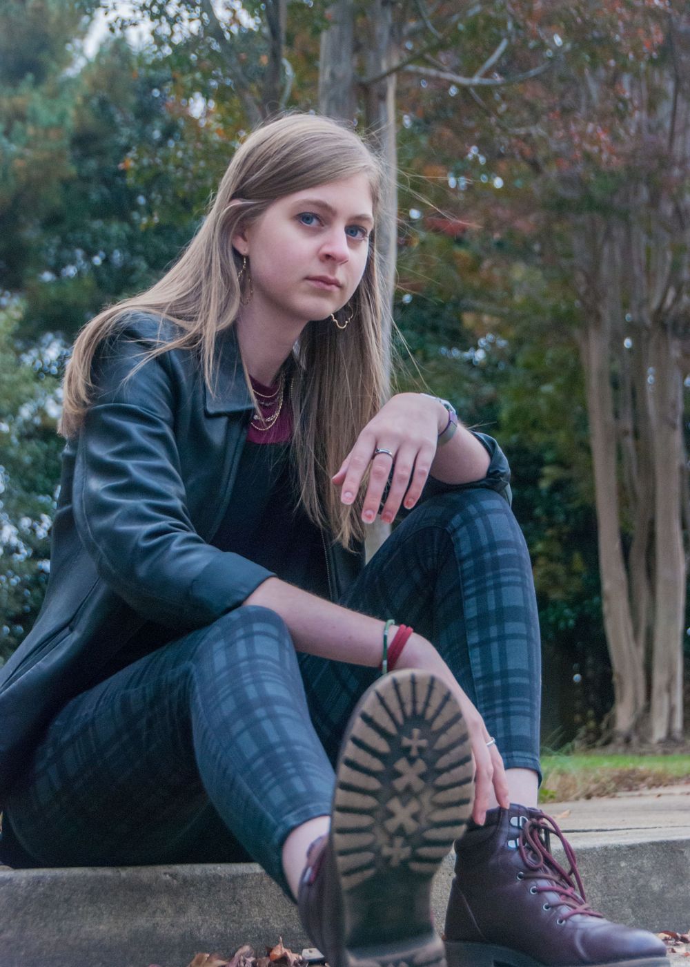 Woman in combat boots, sitting on curb in Greenville, South Carolina