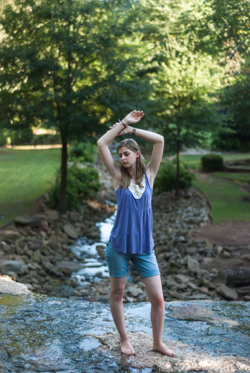 Woman standing on top of a waterfall in Greenville, South Carolina