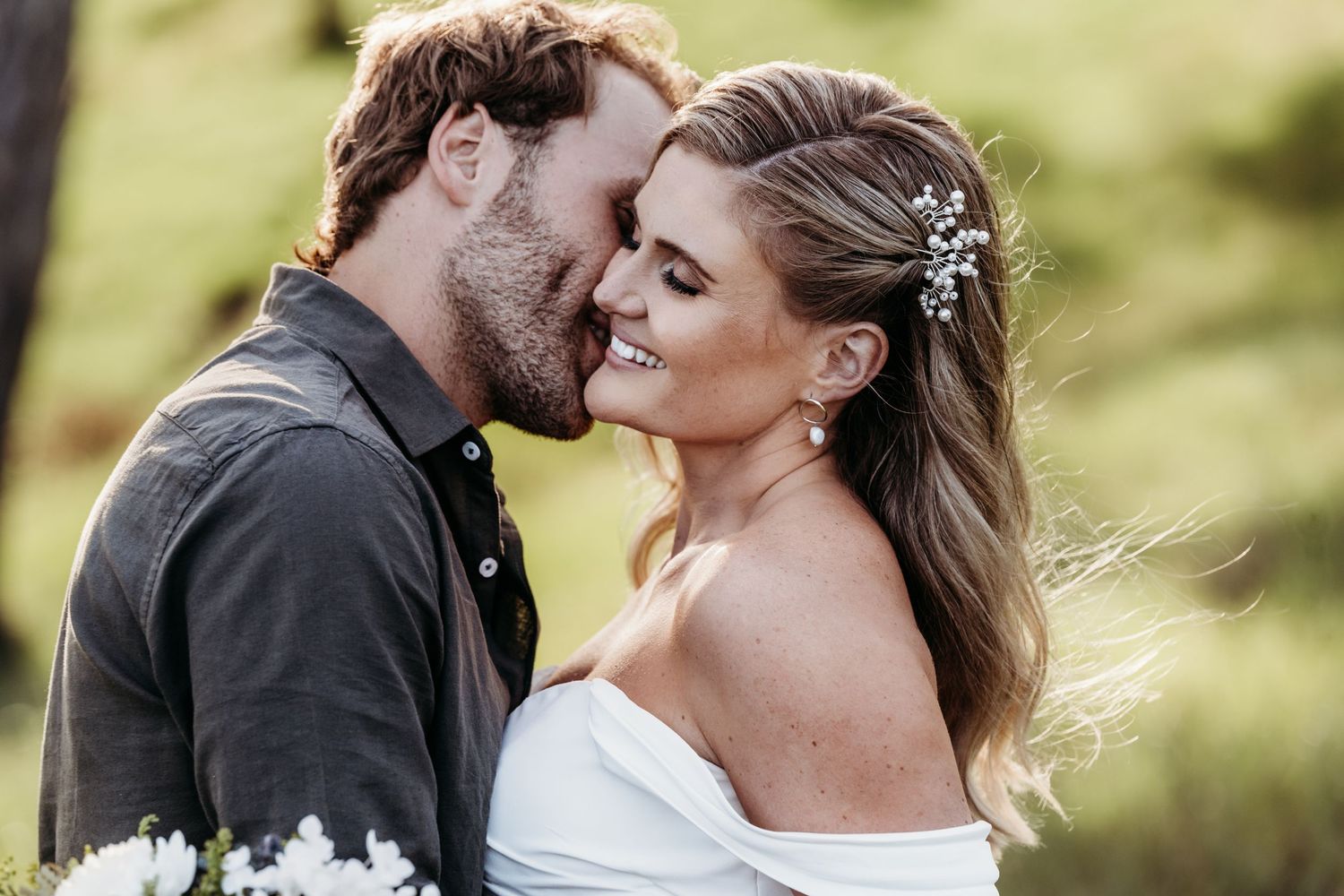 A romantic outdoor wedding portrait of a couple in formal attire.