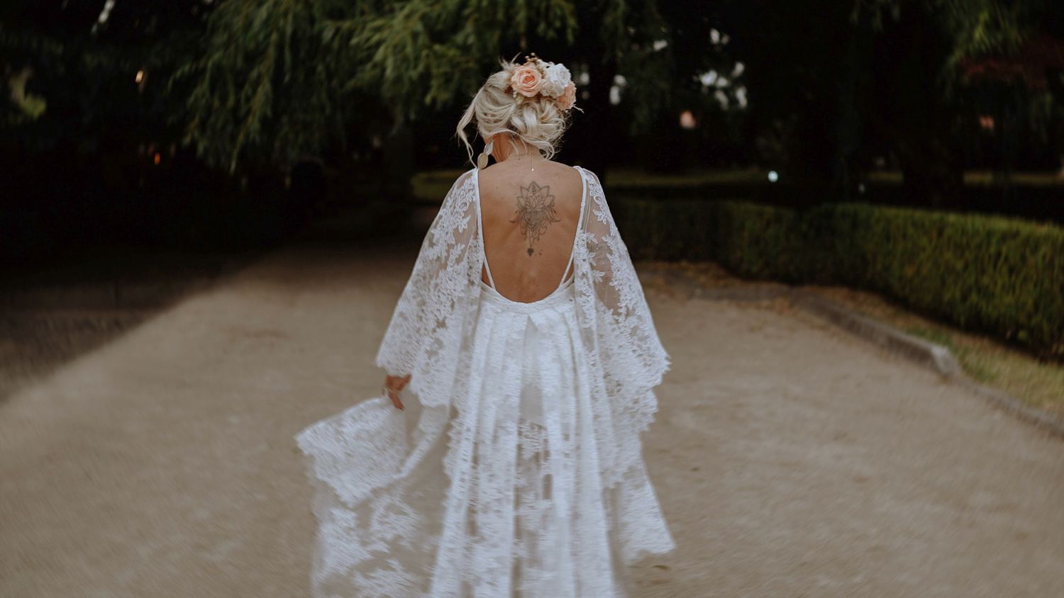 A back view of a bride in a stunning lace wedding dress with an open back detail.