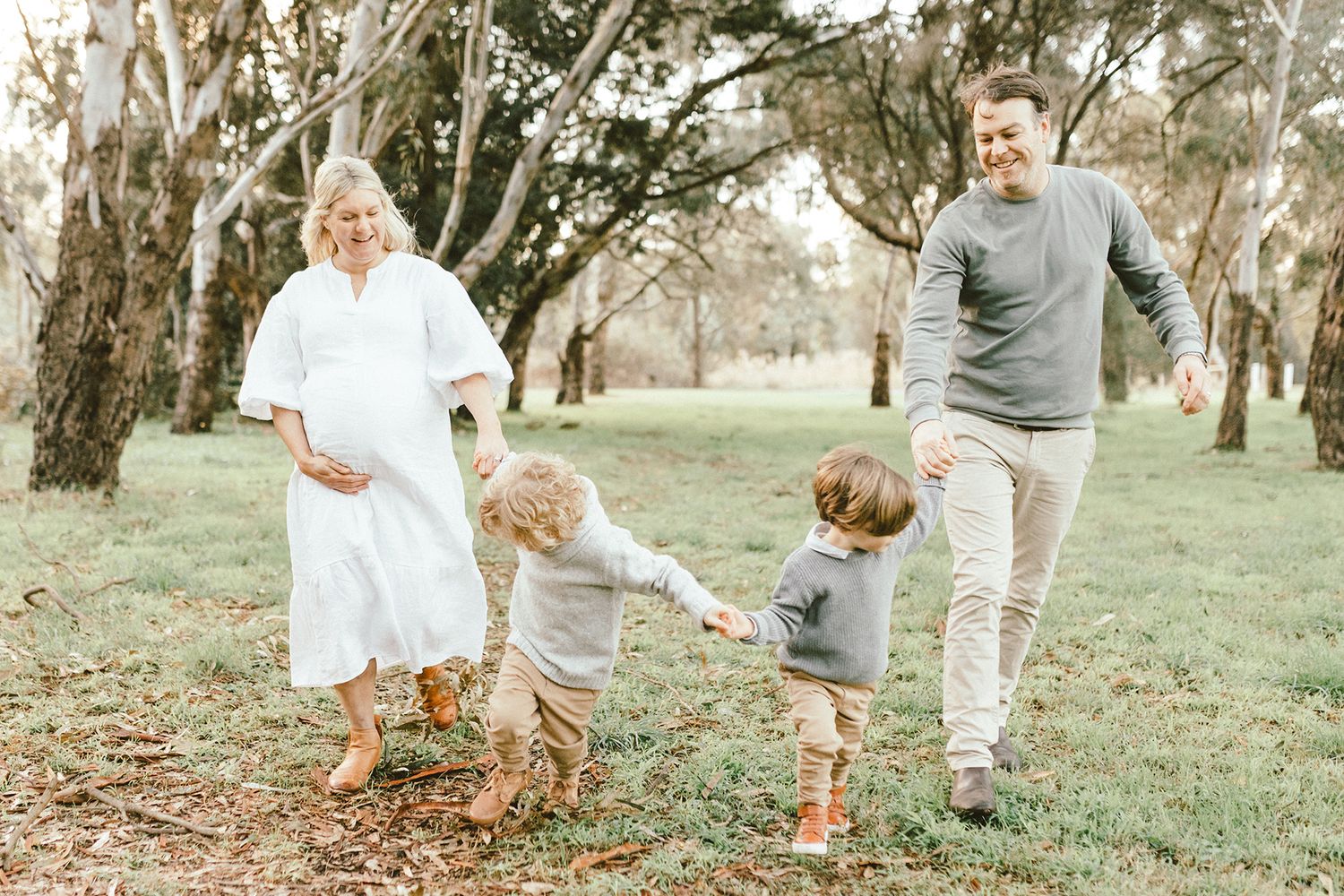 Family enjoying a playful moment together while walking through a wooded area.