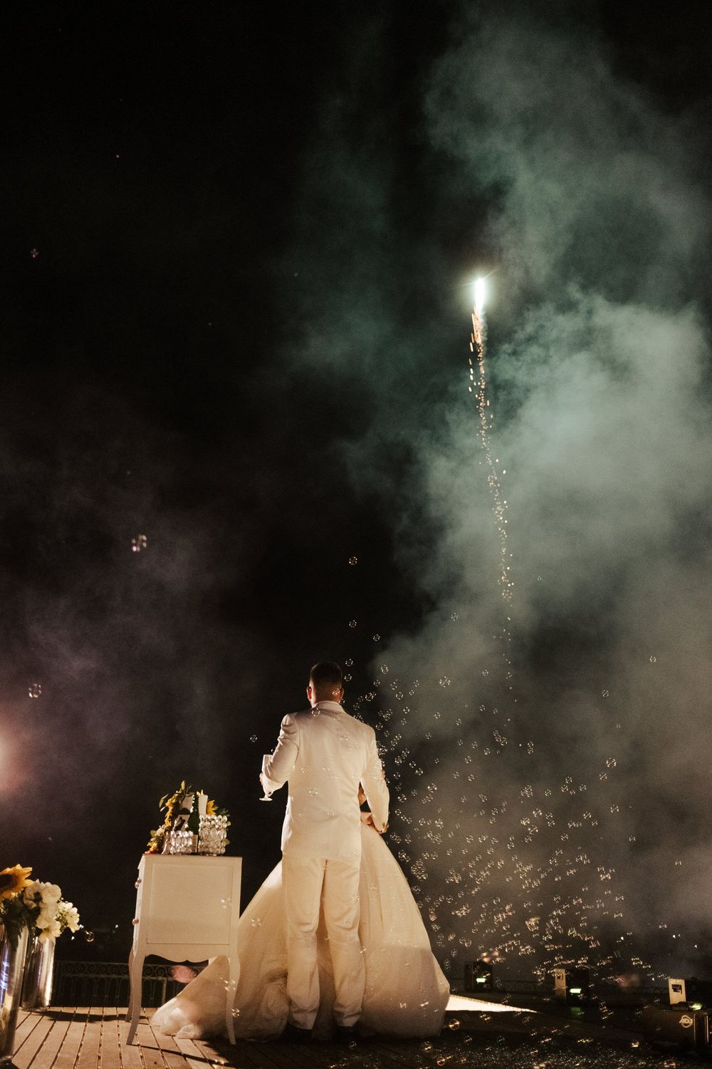 Cena dramática de casamento noturno com velas de faísca criando um efeito mágico de silhueta.