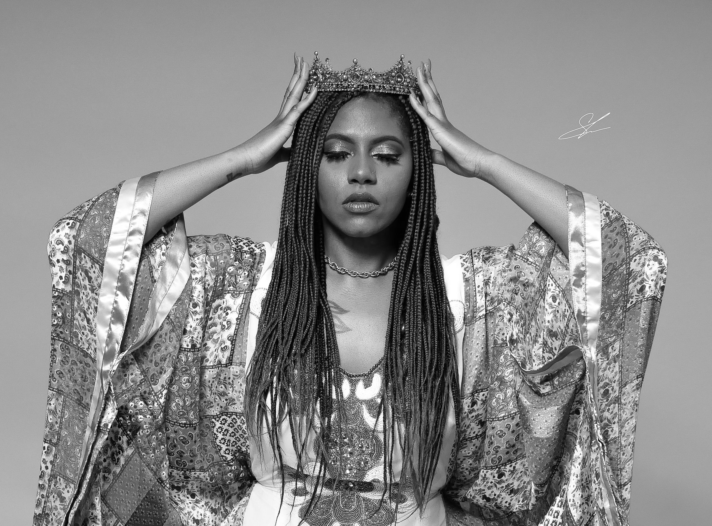 Dramatic black and white portrait in patterned kimono with long braided hair.