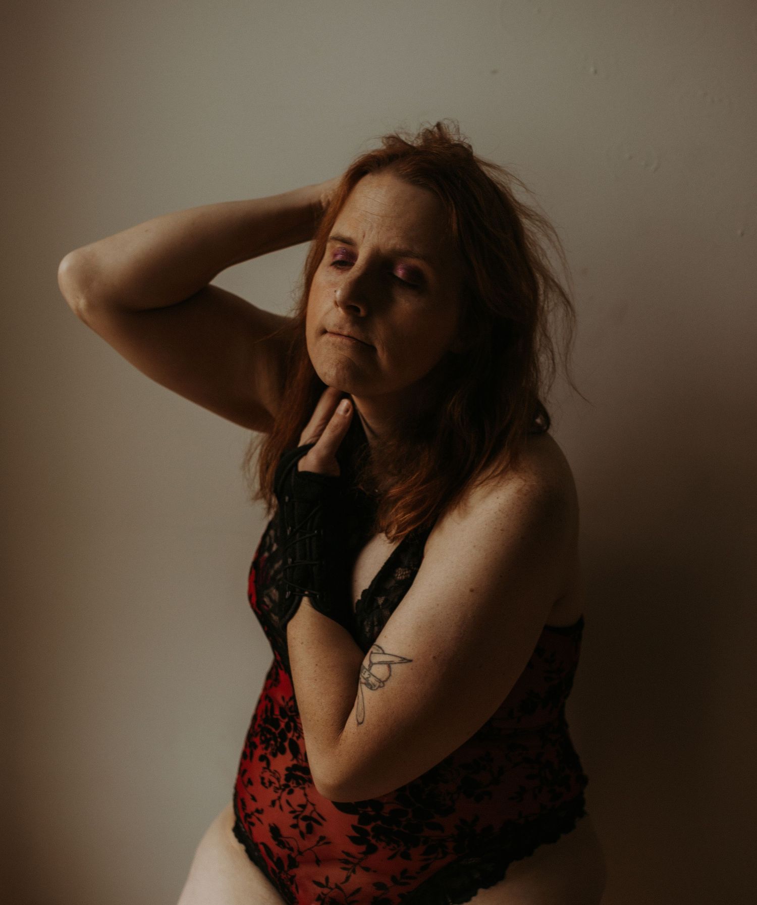 Moody portrait taken in warm shadows with dramatic lighting and muted brown tones.