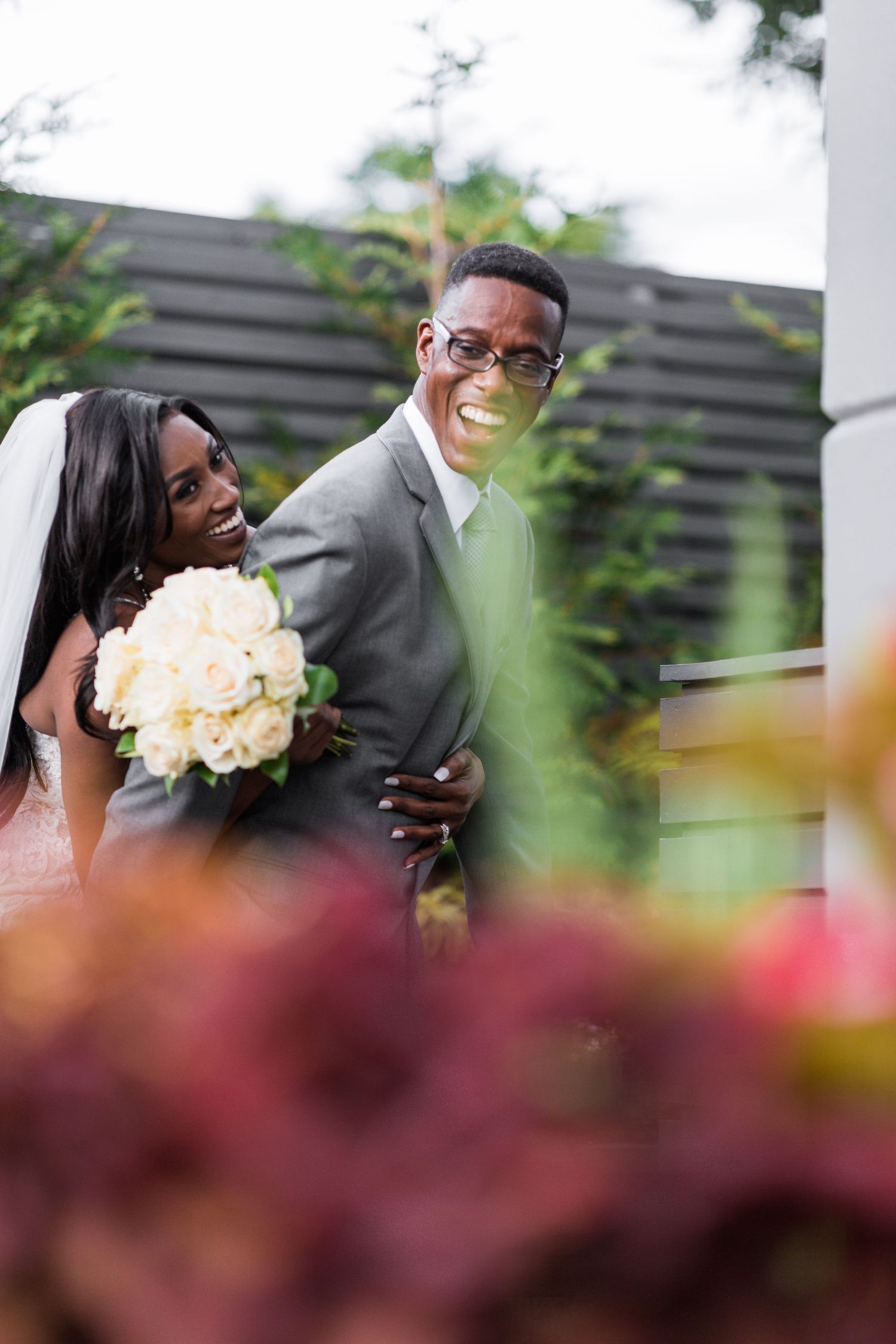 groom smiling back at bride as she hugs him from behind