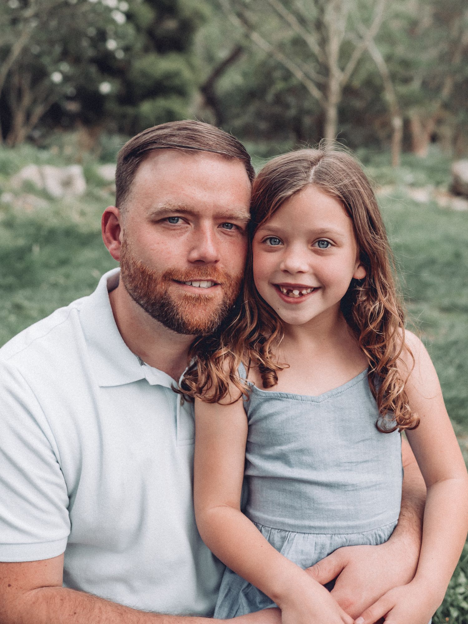 Heartwarming outdoor portrait in a garden setting with soft natural lighting.
