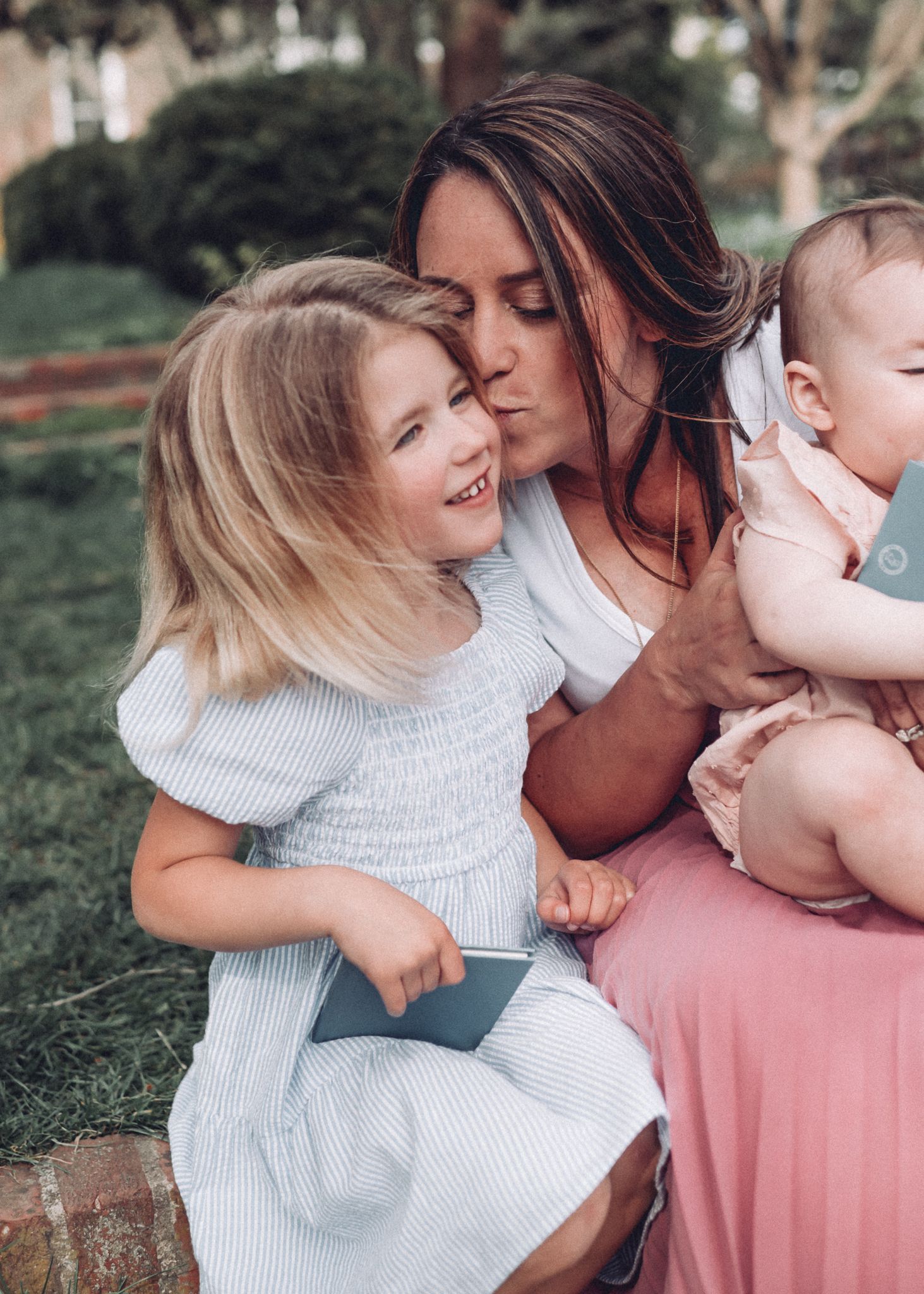 Tender family moment captured outdoors with soft lighting and natural expressions.