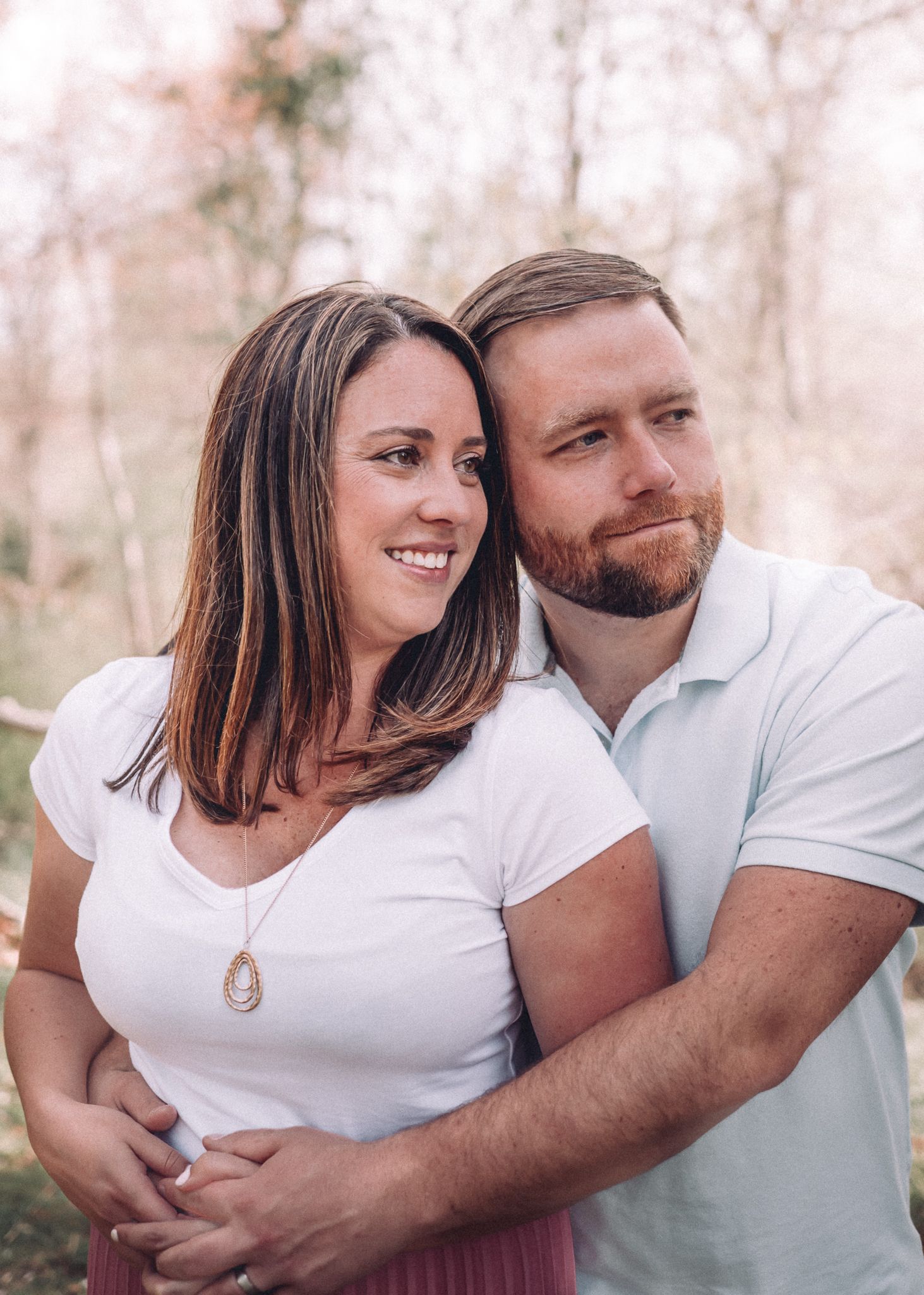 Romantic couple portrait outdoors with both wearing white polo shirts.