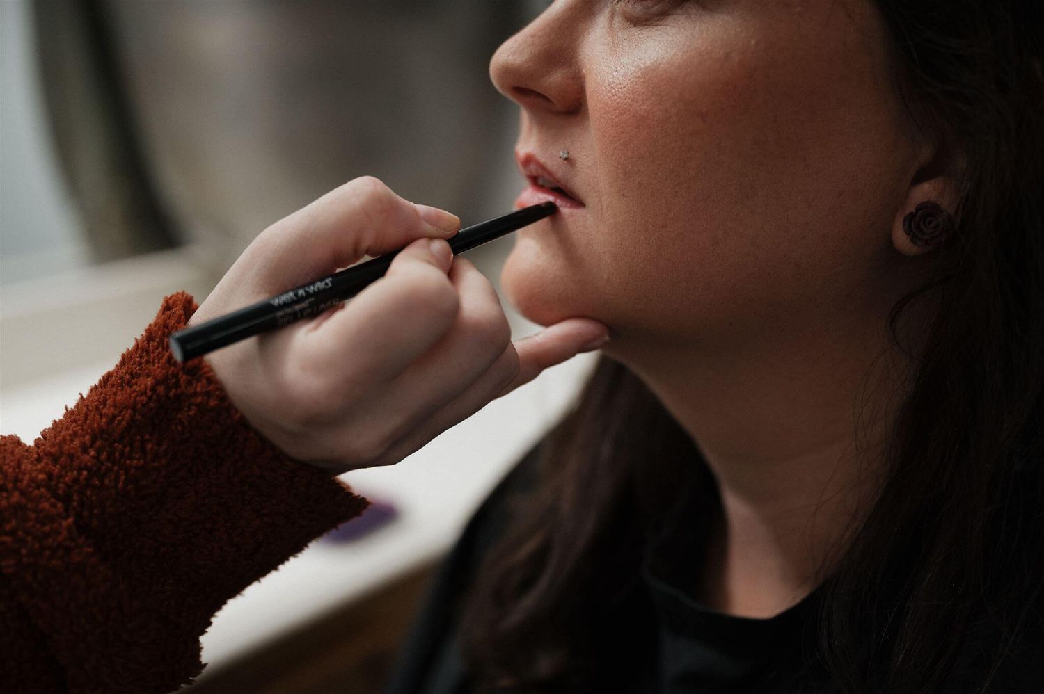 Close-up shot of makeup being applied with a brush.