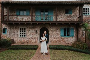 Classic colonial architecture with turquoise details frames elegant portrait in vintage setting.
