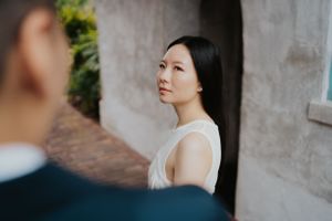 Artistic side profile portrait against textured stone wall in natural lighting.