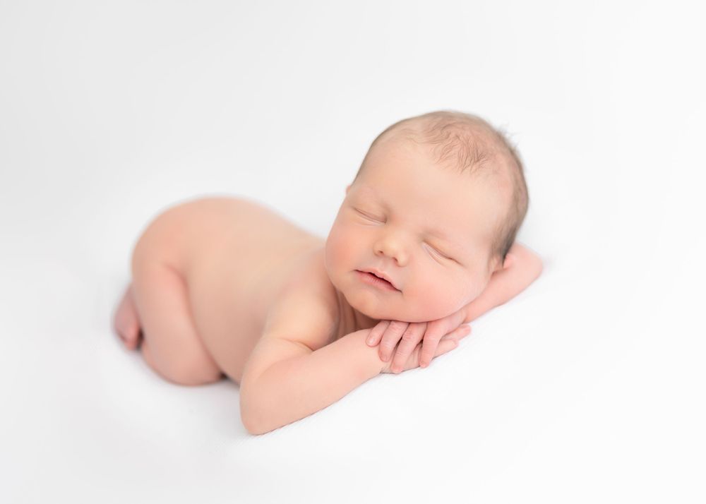 baby asleep on white blanket, newborn baby photographer near me, east ivy, family photos, cake smash photo session