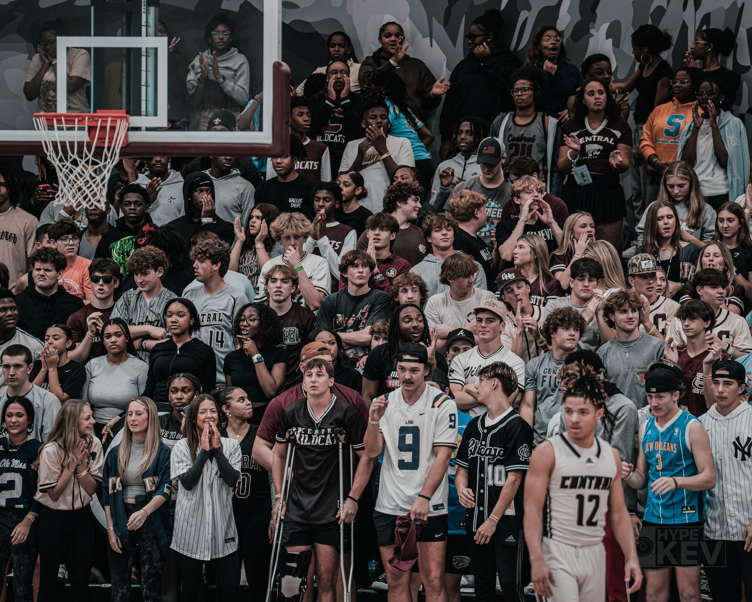High school basketball fans packed into bleachers watching an intense game.
