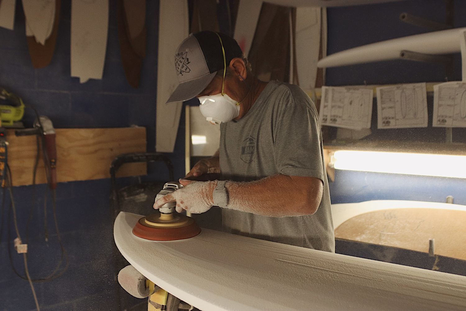 surf board designer in shaping bay working
