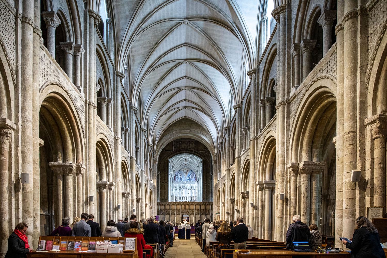 Panoramic view of a majestic cathedral interior with soaring stone columns and vaulted ceiling.