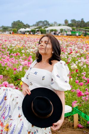 A joyful moment captured in a blooming flower field with a black hat.