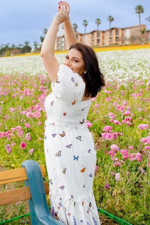 A carefree pose among pink and white cosmos flowers in a spring garden.