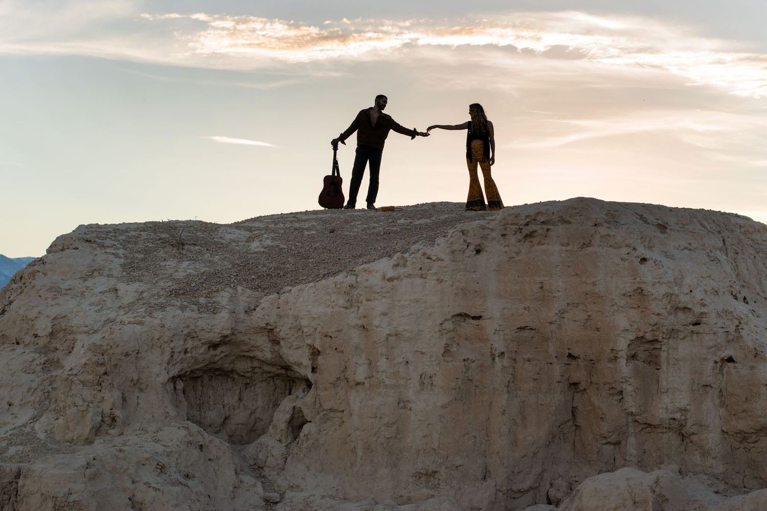 ALT= " SILHOUETTE PHOTO COUPLE WITH GUITAR IN THE DESERT ON A MOUNTAIN"